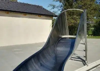 Stainless steel water slide by the pool, water inlet