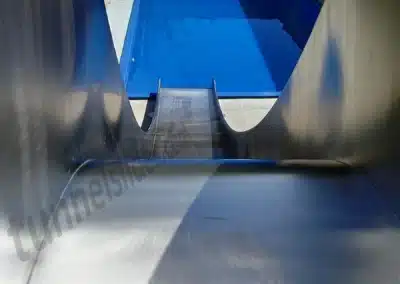 Stainless steel water slide by the pool, top view.