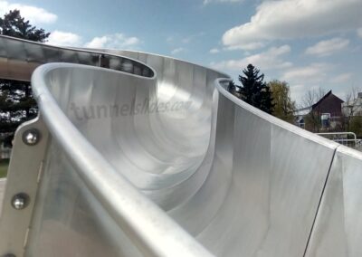 Detail of the trough of a large stainless steel water slide.