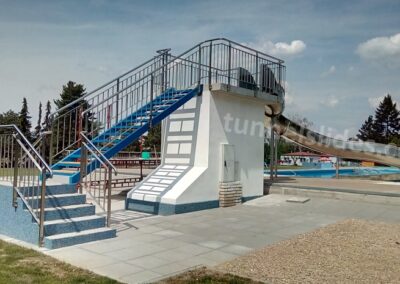 Large stainless steel water slides for various towers and platforms.