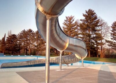 Stainless steel slide at a public swimming pool.